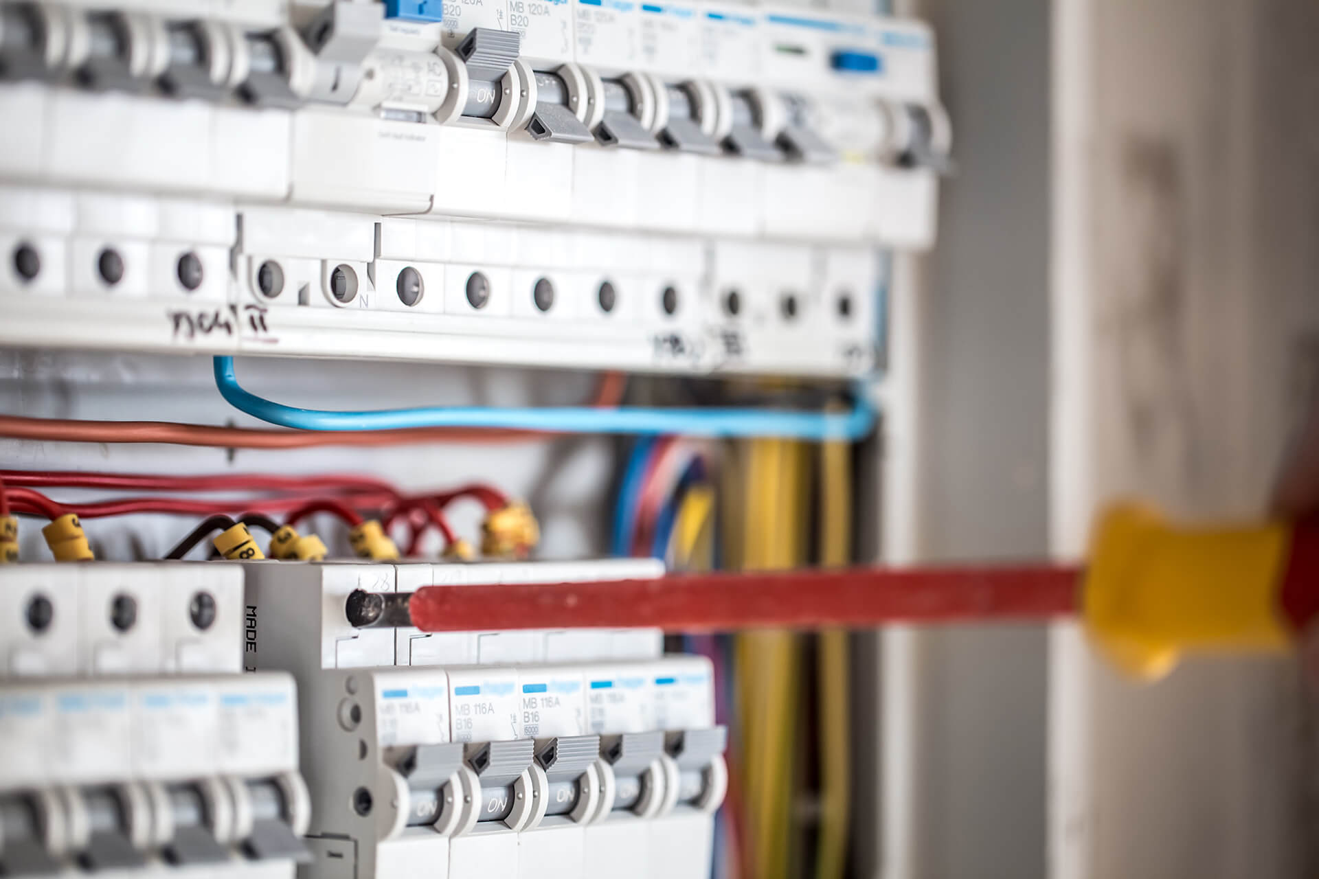 electrical technician working switchboard with fuses installation connection electrical equipment close-up
